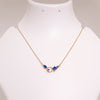 Necklace with blue and gold beads on a white mannequin bust against a light gray background
